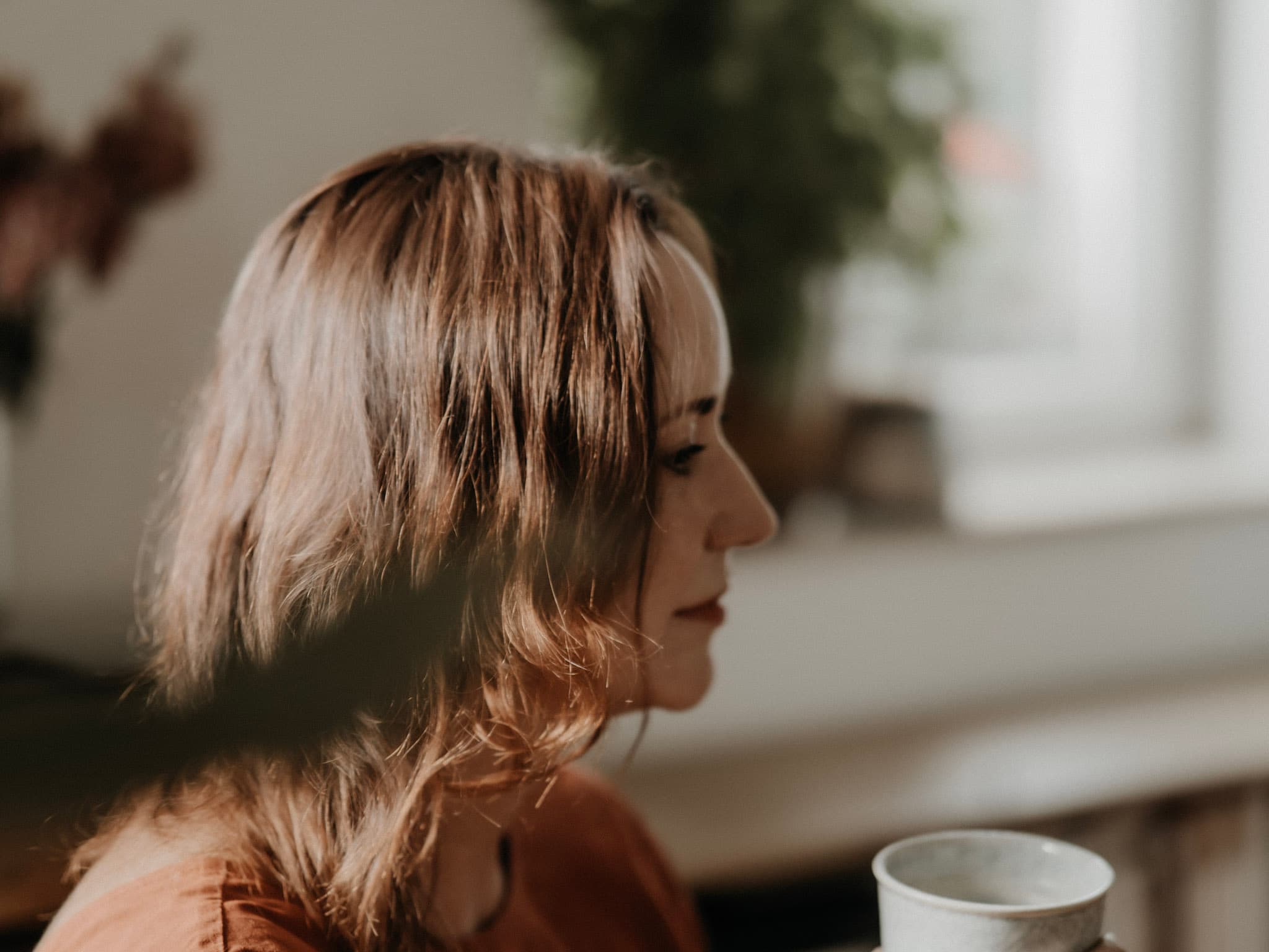 Anja Wolfram im Profil, nachdenklich, mit einem Becher in der Hand