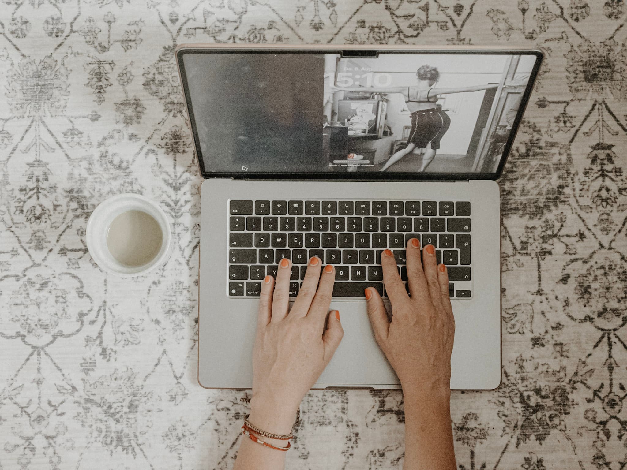 Laptop und Kaffeetasse von oben, während eines Online-Termins