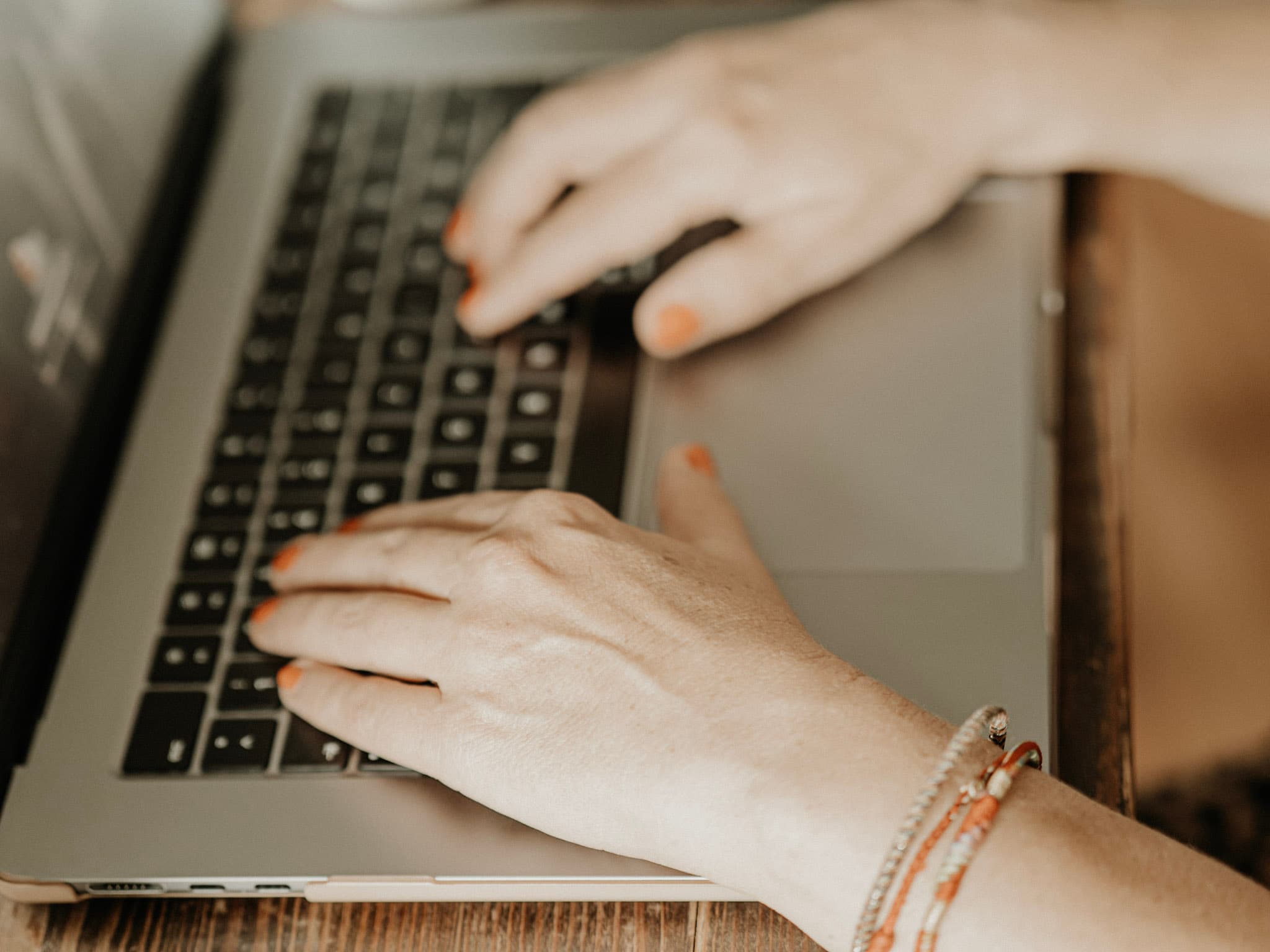 Hände auf der Tastatur eines Laptops