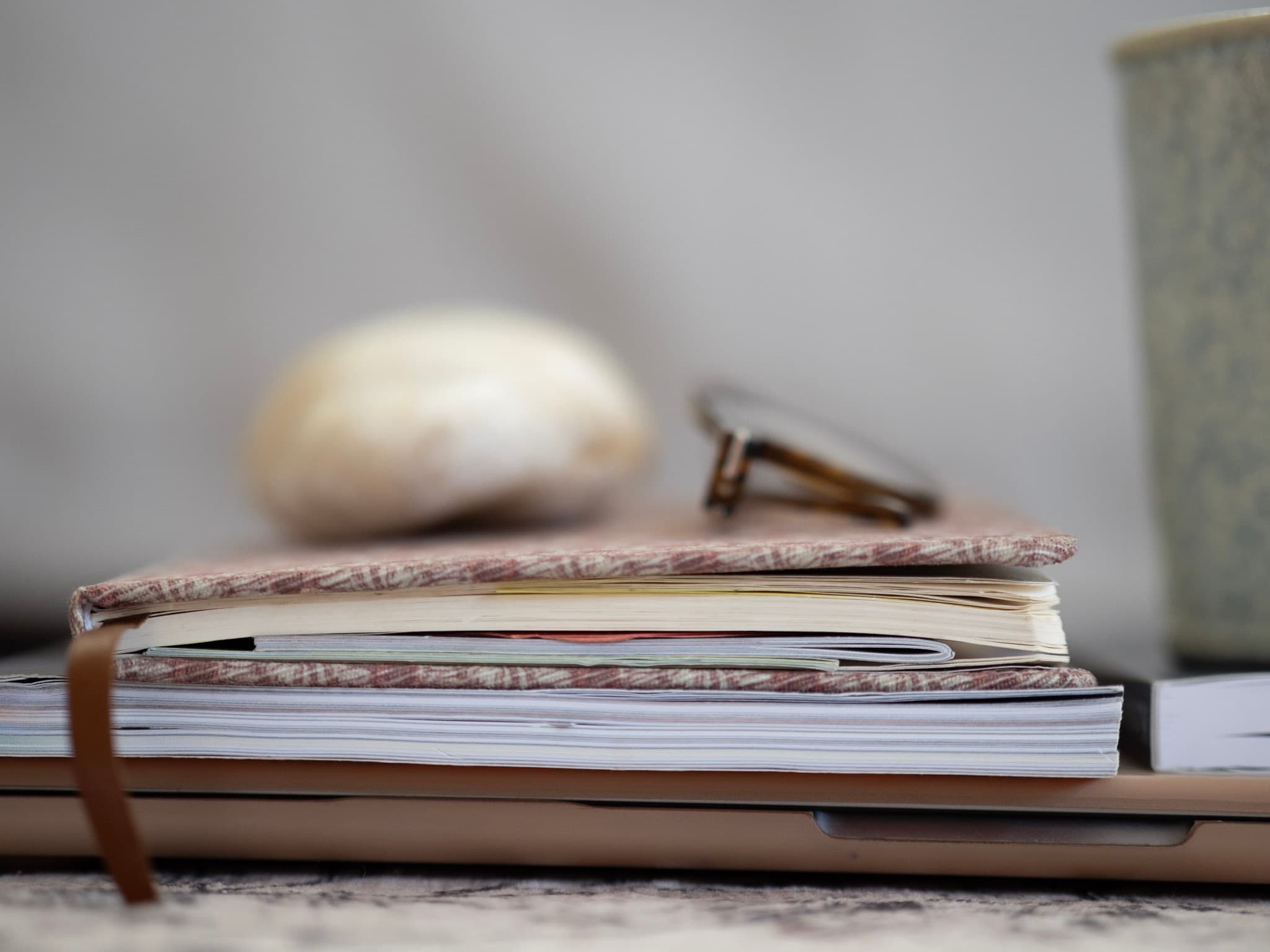 Notizbuch, Brille und ein Stein auf einem Tisch